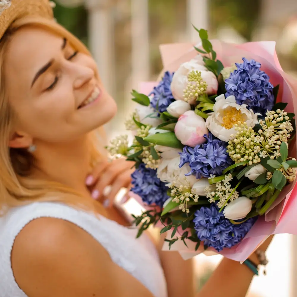 Mother holding fresh bouquet of hyacinths and peonies
