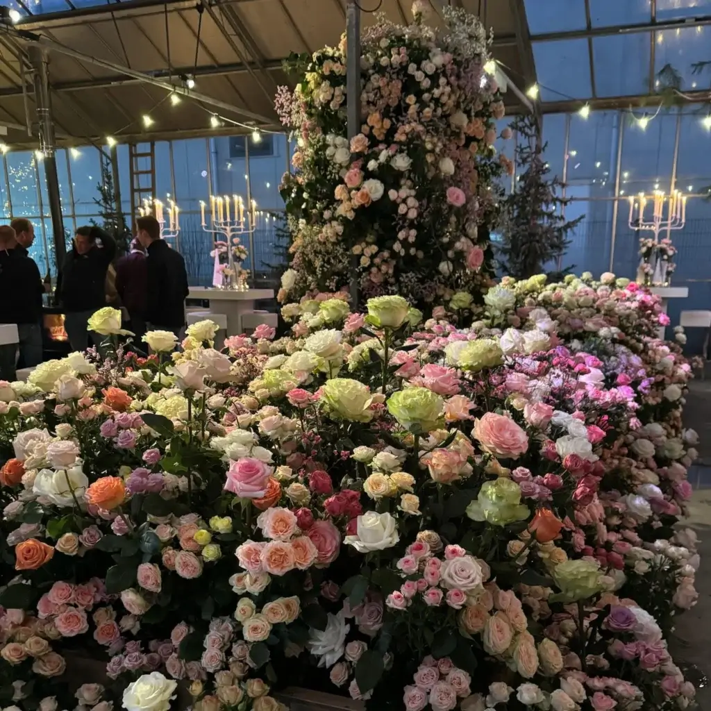 Large-scale floral installation featuring roses in pink, peach, white, and mauve