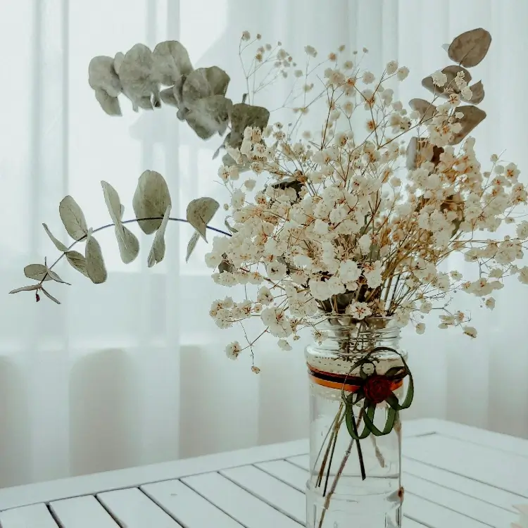 Mason jar flower arrangement with baby’s breath and eucalyptus, combining fresh and dried stems