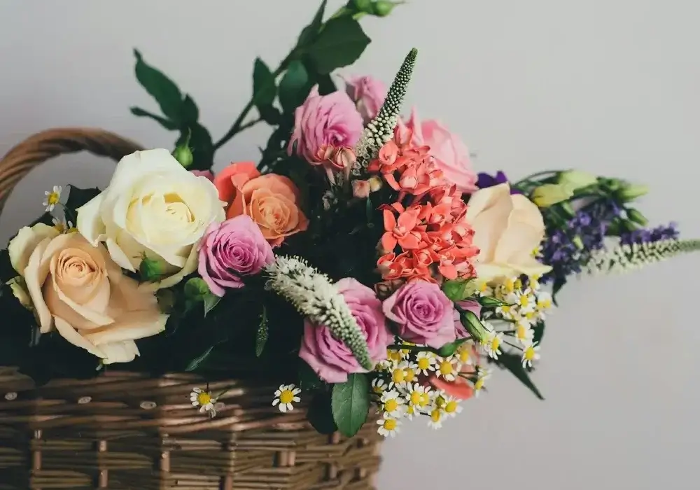 Mixed Mother's Day flowers including roses and spring blooms arranged in a wicker basket